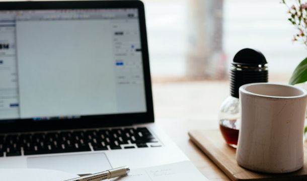 Laptop, book and cup on desk