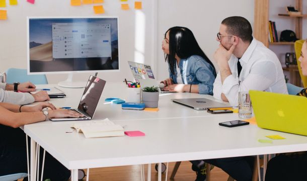 Small team meeting and using computer display