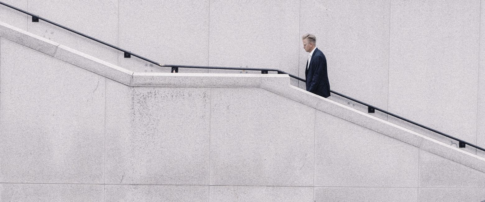 Businessman walking stairs alone and tired