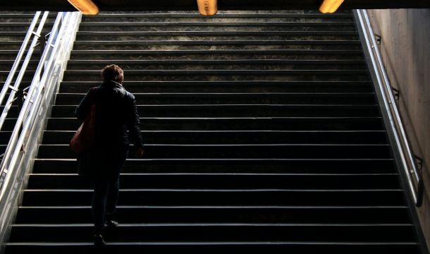 man in black jacket walking on stairs